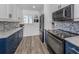 Modern kitchen with blue cabinets, granite counters, and stainless steel appliances at 220 Santa Maria St # 240, Venice, FL 34285