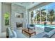 Lush patio with fireplace and seating area overlooking a refreshing pool at 121 Seagull Ln, Sarasota, FL 34236