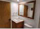 Bathroom features a vanity sink with wooden frame mirror and toilet at 8010 Marina Dr, Holmes Beach, FL 34217