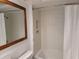 Bathroom with white subway tile shower and a framed mirror at 8010 Marina Dr, Holmes Beach, FL 34217