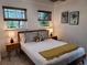 Cozy bedroom features a bed with two side tables and two windows at 8010 Marina Dr, Holmes Beach, FL 34217