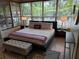 Main bedroom features a large bed, bench, wood blinds, and side tables with lamps at 8010 Marina Dr, Holmes Beach, FL 34217