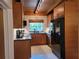 Modern kitchen with wood cabinets and black appliances at 8010 Marina Dr, Holmes Beach, FL 34217