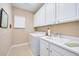 Laundry room with washer, dryer, and white cabinets at 13202 Torresina Ter, Bradenton, FL 34211