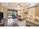 Bright living room with hardwood floors, comfy sofas, and pool view at 13202 Torresina Ter, Bradenton, FL 34211