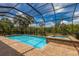 Screened pool and spa with a view of the natural landscape at 5209 Lake Overlook Ave, Bradenton, FL 34208