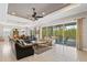 Open living area with leather sofas, large glass doors, and a view of the pool and backyard at 5209 Lake Overlook Ave, Bradenton, FL 34208
