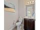 Small bathroom with toilet, vanity, and dark brown cabinets at 5209 Lake Overlook Ave, Bradenton, FL 34208
