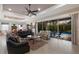 Open living space with leather sofas, glass doors, and view of the pool and dining area at 5209 Lake Overlook Ave, Bradenton, FL 34208