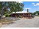 Charming single-story home with a wraparound porch, metal roof, and mature landscaping at 7416 41St E Ave, Bradenton, FL 34208