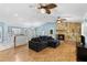 Cozy living room with a stone fireplace, ceiling fans, and an open layout to the kitchen at 7416 41St E Ave, Bradenton, FL 34208