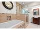 Luxurious bathroom featuring a soaking tub, glass enclosed shower, and elegant vanity at 808 Ponderosa Pine Ln, Sarasota, FL 34243