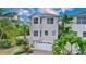 Tan three-story house with white garage door and palm trees at 219 81St St, Holmes Beach, FL 34217