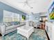 Spacious living area featuring light-colored furniture and a large TV at 219 81St St, Holmes Beach, FL 34217
