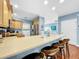 Open kitchen with light wood cabinets, stainless steel appliances, and a breakfast bar at 219 81St St, Holmes Beach, FL 34217