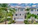 Tan three-story house with white garage door and palm trees at 219 81St St, Holmes Beach, FL 34217