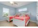 Charming bedroom with twin beds, ceiling fan, and views of lush outdoor landscape at 4805 2Nd Ave, Holmes Beach, FL 34217