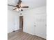 Neutral bedroom with hardwood floors, a ceiling fan, and two doors providing privacy at 7380 Mikasa Dr, Punta Gorda, FL 33950