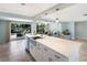 Bright kitchen with tile floors, a large island with seating, and direct access to the outdoor area at 506 69Th St, Holmes Beach, FL 34217