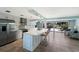 Bright kitchen boasts white cabinetry, stainless appliances, island with breakfast bar, and seamless access to the outdoor patio at 506 69Th St, Holmes Beach, FL 34217