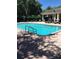 Community pool with covered patio and lounge chairs at 5146 Northridge Rd # 201, Sarasota, FL 34238