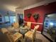 Red-walled dining area with a round glass table and floral chairs at 5146 Northridge Rd # 201, Sarasota, FL 34238