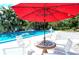 Relaxing poolside seating area with red umbrella at 3225 Duncan Way, Sarasota, FL 34239