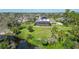 An aerial view of a home with solar panels on the roof and screened in pool surrounded by green grass at 6722 Oakmont Way, Lakewood Ranch, FL 34202