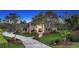 Stunning brick two-story home with a well manicured lawn and mature landscaping and circular driveway at 6722 Oakmont Way, Lakewood Ranch, FL 34202