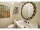 Well-lit half-bathroom features a decorative mirror, wall art, and pedestal sink at 6722 Oakmont Way, Lakewood Ranch, FL 34202
