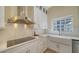 Close-up of a bright kitchen featuring an apron sink, modern appliances, and designer finishes at 6722 Oakmont Way, Lakewood Ranch, FL 34202