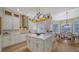 Bright and modern kitchen with white cabinets, an island, breakfast nook and hardwood floors at 6722 Oakmont Way, Lakewood Ranch, FL 34202