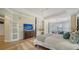 Spacious main bedroom with four-poster bed, dresser with TV, and sitting area with bay windows at 6722 Oakmont Way, Lakewood Ranch, FL 34202