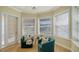Cozy sitting area with two teal chairs, a small table, and large windows with natural light at 6722 Oakmont Way, Lakewood Ranch, FL 34202
