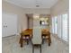 Formal dining room with a wood table and four light beige chairs, near kitchen and access to patio at 424 Cardiff Rd # 27, Venice, FL 34293