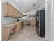 Galley kitchen with stainless steel appliances and light wood cabinets at 424 Cardiff Rd # 27, Venice, FL 34293