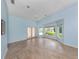 Spacious bedroom with light blue walls, tile floors, and access to the patio at 424 Cardiff Rd # 27, Venice, FL 34293