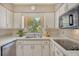 Clean kitchen with white cabinets, a window, and a view to the backyard at 3225 Duncan Way, Sarasota, FL 34239