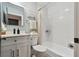 Bright bathroom featuring shiplap walls, white cabinets, and a tub with white tile surround at 4343 Pompano Ln, Palmetto, FL 34221