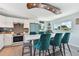 A well-lit kitchen island offers seating, complimented by white cabinets and stainless steel appliances at 4343 Pompano Ln, Palmetto, FL 34221