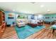 Bright living room featuring hardwood floors, comfy sectional sofa, and a teal rug at 5911 Braden Run, Bradenton, FL 34202