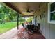 Relaxing covered patio with seating area, overhead fan, and view of the backyard at 5911 Braden Run, Bradenton, FL 34202