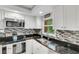 Modern kitchen with white cabinets, granite counters, and stainless steel appliances at 2323 Waterbluff Pl # V314, Sarasota, FL 34231