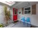 Inviting front entry with red door, blue chairs, and landscaping at 2323 Waterbluff Pl # V314, Sarasota, FL 34231