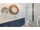 Modern bathroom with navy blue vanity, walk-in shower, and stylish mirror at 108 Tern Dr, Anna Maria, FL 34216
