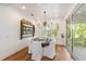 A bright dining room with a wooden table, white chairs and a wooden shelf at 108 Tern Dr, Anna Maria, FL 34216