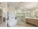 Modern bathroom with soaking tub, glass shower, and light wood cabinets at 108 Tern Dr, Anna Maria, FL 34216