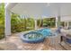 Relaxing pool and spa area with a covered patio and comfortable seating at 108 Tern Dr, Anna Maria, FL 34216