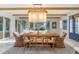 Bright dining room with a large wooden table and wicker chairs at 108 Tern Dr, Anna Maria, FL 34216