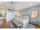 Main bedroom with king bed, light blue walls and barn door to the bathroom at 108 Tern Dr, Anna Maria, FL 34216